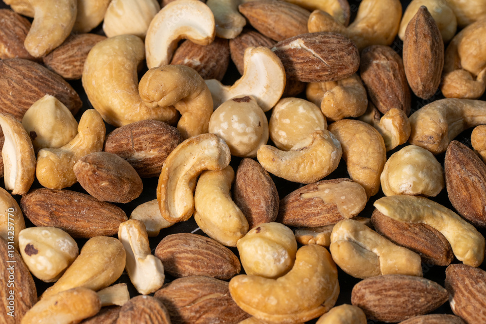 Obraz premium a dense, textured variety of mixed nuts, including smooth cashews and ridged almonds.
