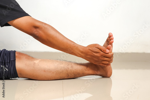 Man stretching foot and leg muscles for flexibility and fitness