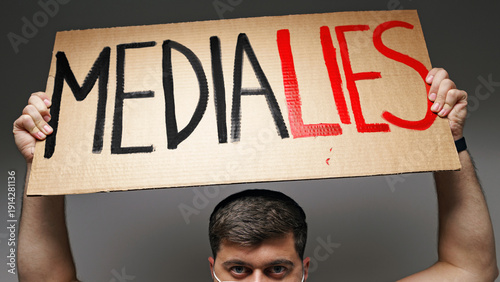 Фотография Protester holds sign saying media lies during demonstration showing public disse