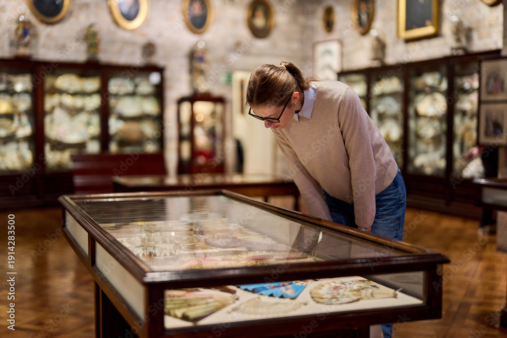 Fototapeta premium visitor in historical museum looking at art object