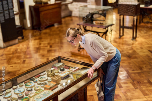visitor in historical museum looking at art object