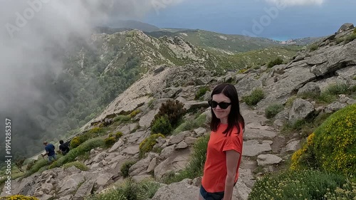 A woman descends from a high mountain on the island of Elba.