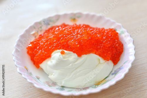Red caviar mixed with sour cream in a plate