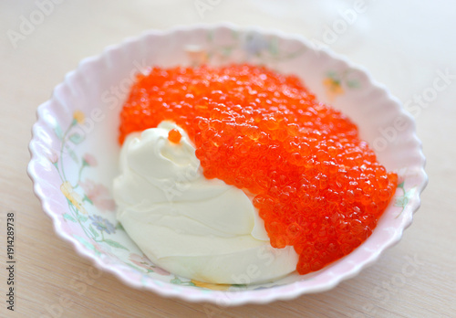 Red caviar mixed with sour cream in a plate