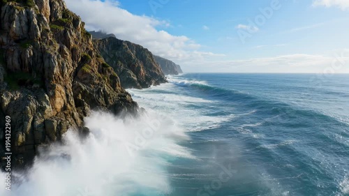 Crashing waves against rugged rocky coastline with blue ocean - 4k video