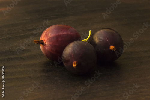 Ripe gooseberries on dark wooden surface