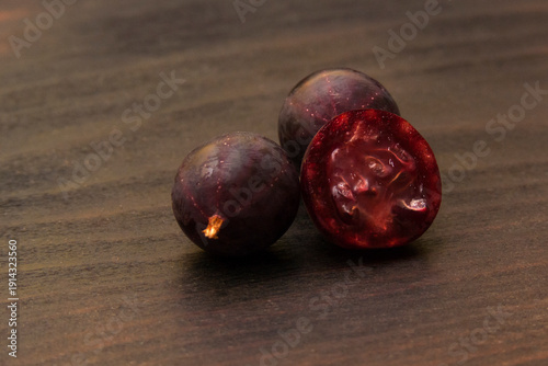 Sliced ripe gooseberry on dark wood background
