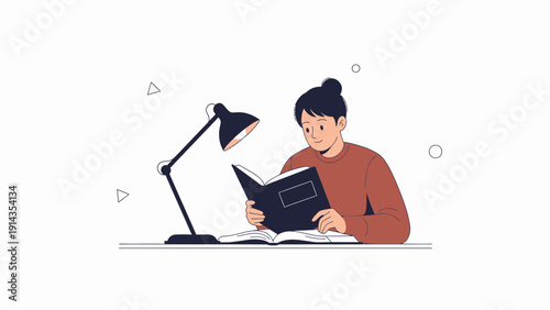 Young person reading a book under a desk lamp, studying or learning concept