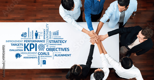 Tableau sur toile A diverse team collaborates around a table, focusing on key performance indicators and strategic goals, enhancing business efficiency and aligning objectives for success