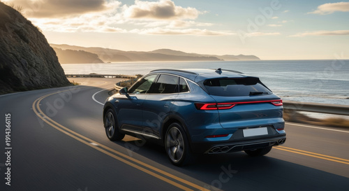 Blue modern SUV driving on a winding scenic coastal road during golden hour at sunset