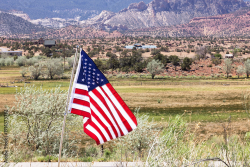 American Flag Waving in the Breeze in Torrey Utah With Mountains and Fields in the Background