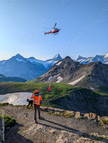 Faulhorn, Switzerland - August 13, 2025 - A helicopter bringing the daily goods to a mountain hotel in the Swiss alps
