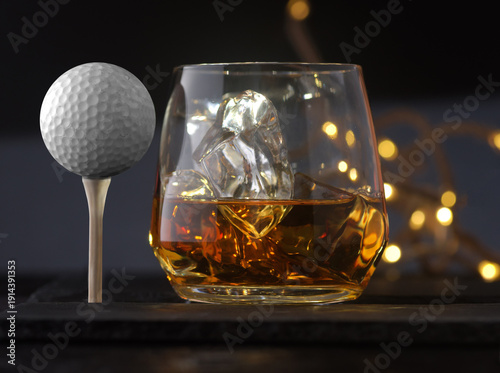 Glass of whiskey with ice cubes and golf ball on black background