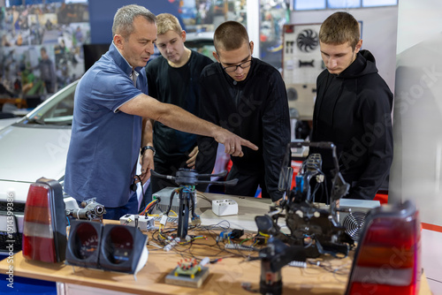 Foto Teacher educating young students in automotive electronics class