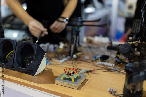 Person working on electronic circuit board and car components