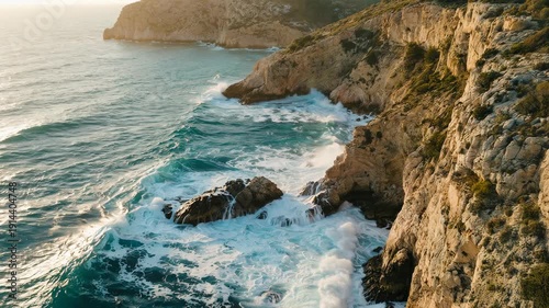 Aerial drone view of tropical coastline with cliffs and splashing waves, slow motion cinematic shot, warm summer colors, paradise vacation scenery, smooth motion over sea rocks