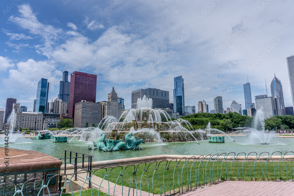 Fototapeta premium The fountain is surrounded by a green park and a fence