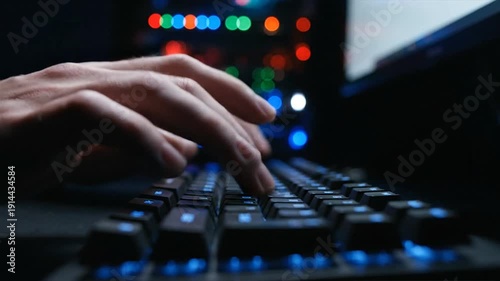 Person typing on keyboard during online scam attack at night with blue keyboard lights