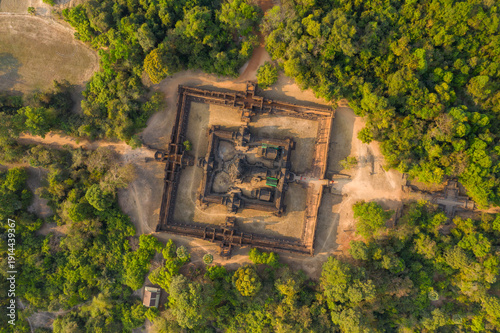 Symmetrical bird's-eye perspective of Banteay Samre temple surrounded by dense tropical forest in the Angkor region. The ancient sandstone complex stands out amid rural clearings under warm daylight