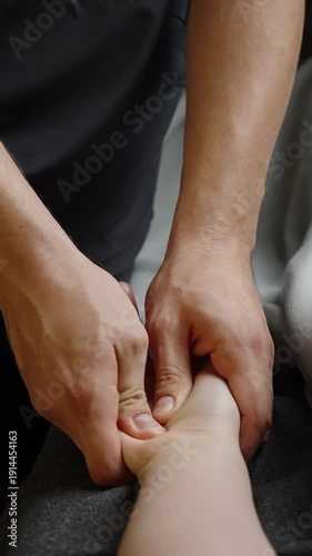 Close-up of professional therapist performing focused palm massage and acupressure, applying firm thumb pressure to relieve tension and promote relaxation in a calm wellness setting