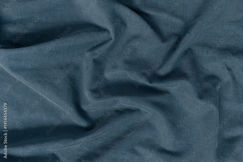 Fototapeta premium Detailed texture of a corduroy fabric background. Top view of a rich blue, navy, denim, slate tone textile material softly draped to create an abstract background