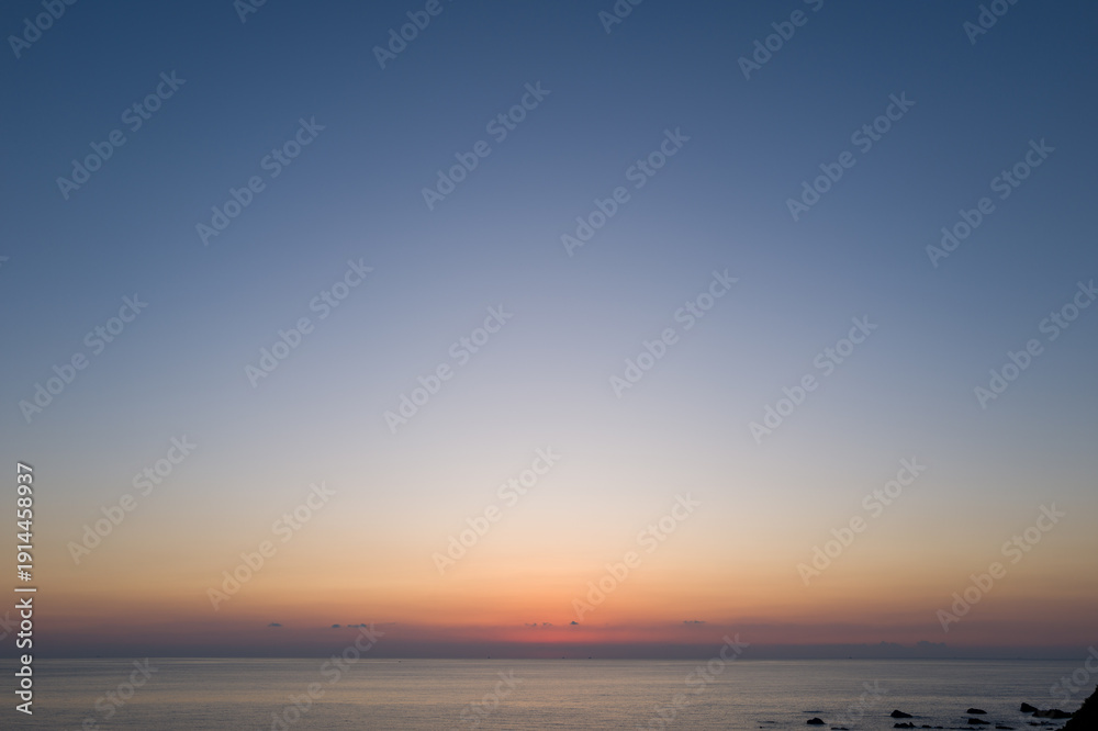 Fototapeta premium Vast open sea under a clear gradient sky at dusk, soft pastel colors blending above calm water with a tranquil horizon in Kushimoto, Japan.
