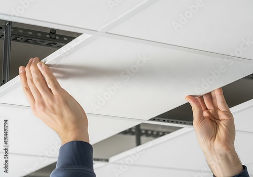 Technician Installing Suspended Ceiling Panel in Modern Office Space