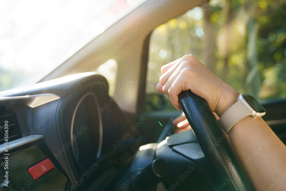 Fototapeta premium Close up of hand on steering wheel with smartwatch