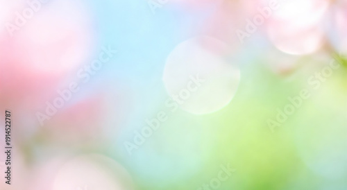 Blurred background with soft pink flowers and bokeh light effects against a blue sky