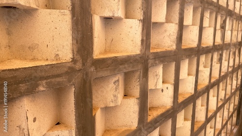 Foto Concrete block wall with a modern, textured, and recessed geometric grid pattern, forming a unique architectural background with strong lines and shadows