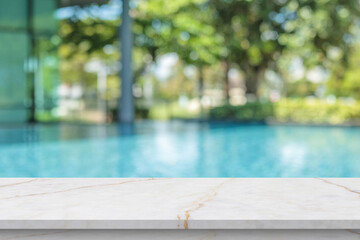 Empty marble table top with blur outdoor swimming pool in tropical resort hotel summer background