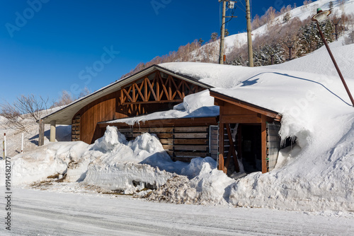 Wooden building buried in deep snow at Yokoteyama ski area in Shiga Kogen, Japan