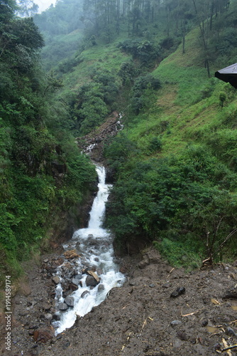 The dramatic flooding and landslides of a waterfall in Pekalongan. The water is cloudy.