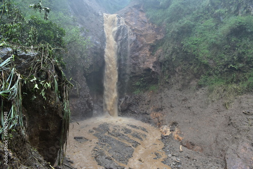 The dramatic flooding and landslides of a waterfall in Pekalongan. The water is cloudy.