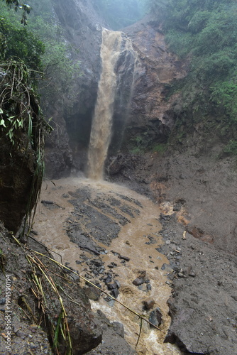 The dramatic flooding and landslides of a waterfall in Pekalongan. The water is cloudy.