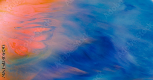Blur dye stream. Ink spill. Orange acrylic emulsion flow on blue texture. Bright wave color mix liquid flow on abstract background.