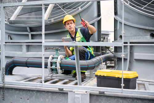 Photography Engineer is inspecting a valve in front of the cooling tower