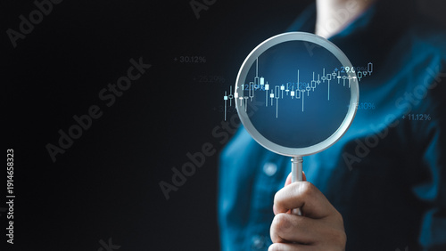 Foto Stock market analysis concept with magnifying glass and financial data chart