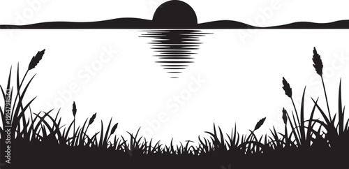 Black and white silhouette of sunset over water with reeds