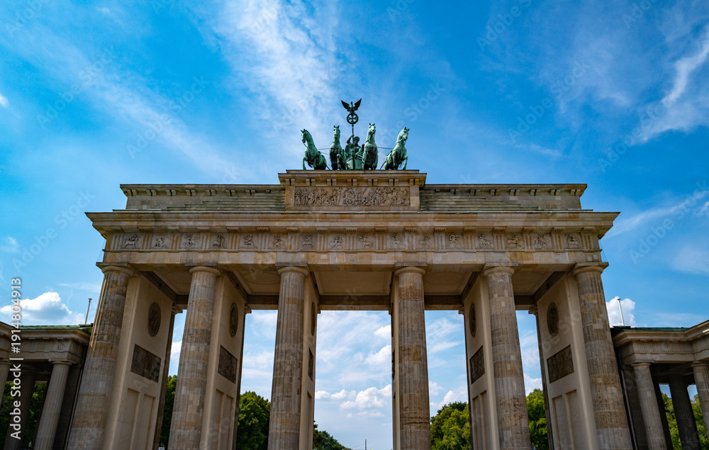 Obraz premium History Brandenburg gate in Berlin under the blue sky. The famous Brandenburg gate in Berlin symbol of peace. Berlins landmark. Architecture in Berlin Germany.