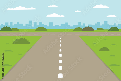 A straight road leads toward a distant city under a bright blue