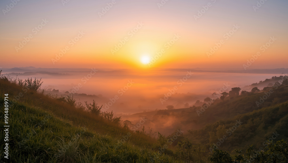Obraz premium Golden sunrise over misty rolling hills with soft light and peaceful atmosphere