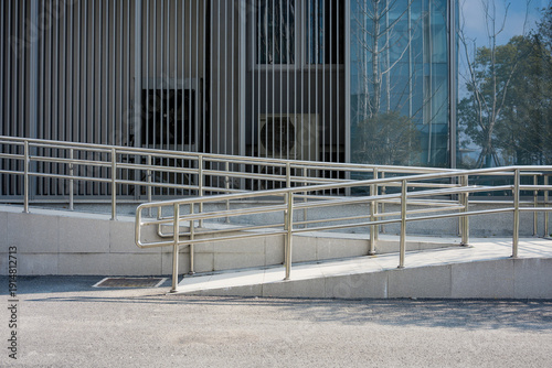 Billede på lærred Modern building exterior with accessible ramp and metal handrails