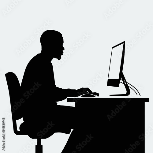 Man typing on computer at desk silhouette