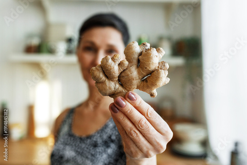 Bild auf Leinwand Selective focus on female hand holding branchy ginger root having anti-inflammat