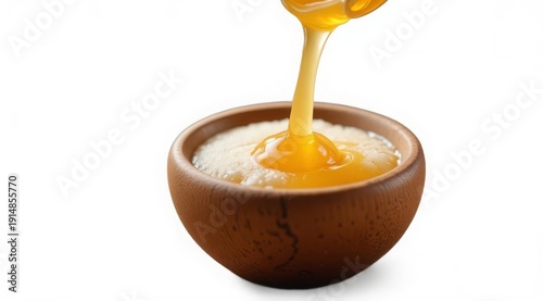 Golden honey drips into a wooden bowl against a soft bokeh background. Stylish food photography for packaging, recipes, or organic product advertisements