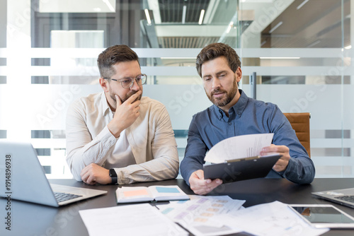 Quadro em tela Experienced businessmen analyzing corporate financial reports, reviewing importa