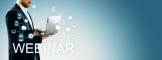 Businessman using laptop for webinar with digital network icons on blue background, promoting online education and internet-based learning.
