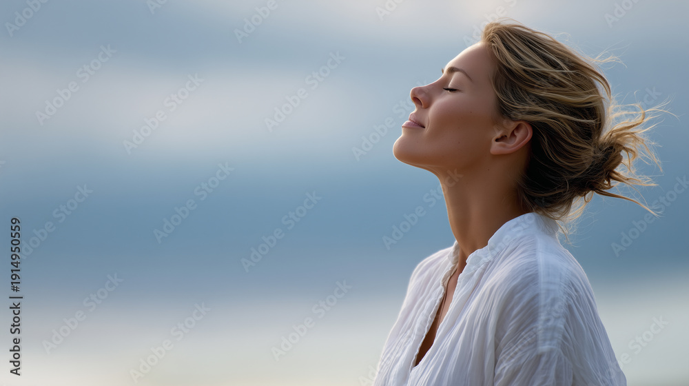 Obraz premium Peaceful woman with eyes closed breathing fresh air outdoors as symbol of mindfulness, relaxation, wellness, and mental health balance.