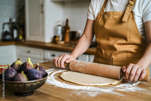 Woman rolling out dough in kitchen